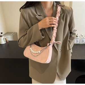 Detail of pink pleated hobo bag with large faux pearls and silver metal chain strap