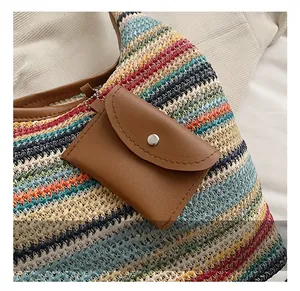 Detail of colorful woven straw tote with brown leather strap and mini coin purse attachment