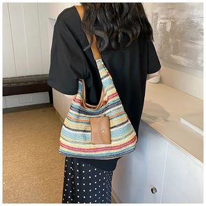 Detail of colorful striped woven tote bag with brown leather straps and mini pouch accessory