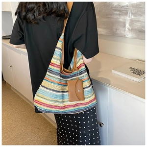 Detail of colorful striped woven tote with leather shoulder strap and small pouch