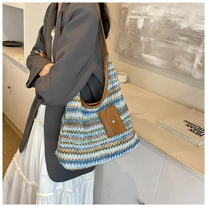 Detail of multi-color woven bucket bag with leather strap and mini coin purse hanging
