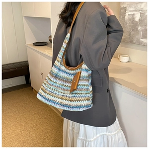 Detail of colorful rainbow straw tote featuring leather strap and matching pouch