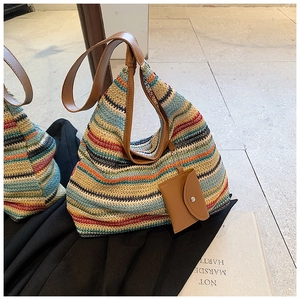 Detail of colorful striped crochet tote bag with brown leather handles and small pouch