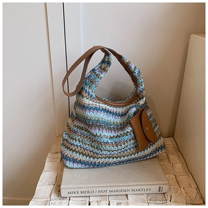 Detail of bohemian rainbow woven tote bag featuring brown leather straps and a matching pouch