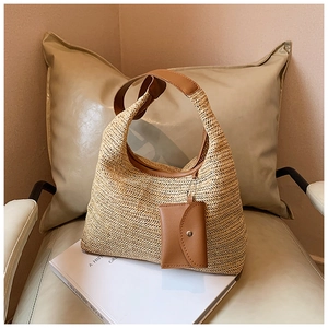 Detail of hand-woven straw tote with brown leather trim and detachable coin purse