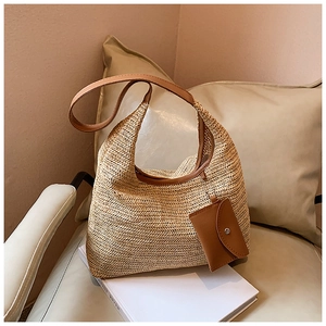Close-up of rainbow straw tote bag featuring herringbone weave and leather pouch