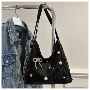 Detail of black velvet shoulder bag with silver bow, pearls and heart rhinestones