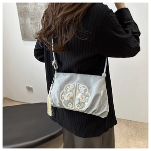 Detail of floral embroidery and silk tassel on a Chinese style crossbody bag
