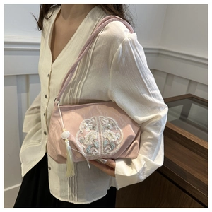 Detailed embroidery and elegant white tassel on a pink satin Chinese style shoulder bag