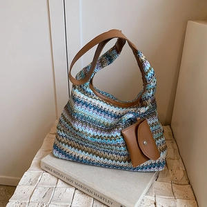 Rainbow woven straw tote bag with multi-colored stripes and matching shoulder strap
