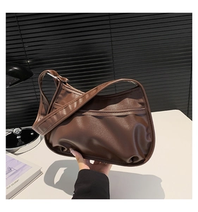 Close-up of soft pleated dark coffee underarm bag with adjustable strap and front pocket