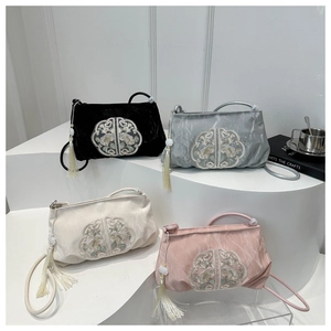 Detail of four embroidered crossbody bags with floral patterns and silk tassels