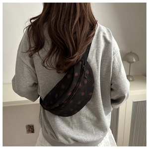 Detailansicht der Cord-Umhängetasche mit Erdbeermuster am Modell in minimalistischem Stil
