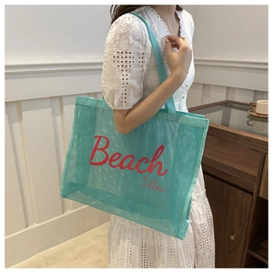 Model showing a large mint green mesh tote bag with Beach Vibes print in a lifestyle setting