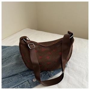Detail of brown corduroy crescent bag with strawberry print and adjustable strap