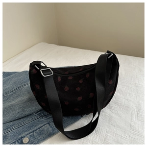 Detail of strawberry embroidery on black corduroy crescent bag with adjustable strap