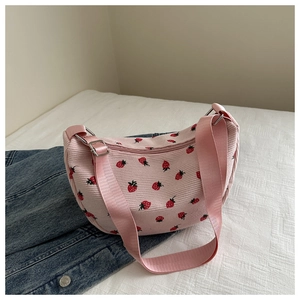 Detailed view of pink corduroy shoulder bag with red strawberry print and zipper