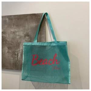 Detail of mint green mesh beach tote with red Beach Vibes text and nylon webbing handles