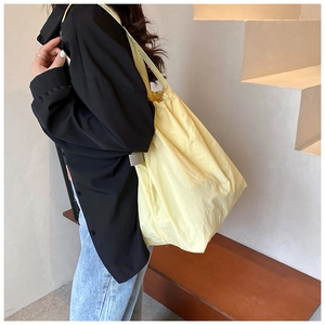 Detailed texture of light yellow nylon tote bag showing minimal Korean style design