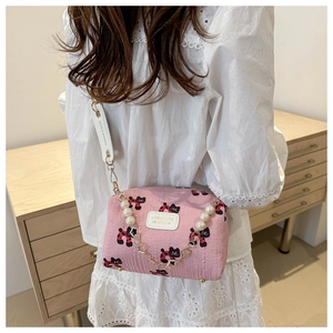 Détail du sac bandoulière rose avec imprimé chat, texture plissée et chaîne perles