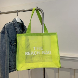 Neon green nylon mesh beach tote bag with THE BEACH BAG lettering and durable web handles