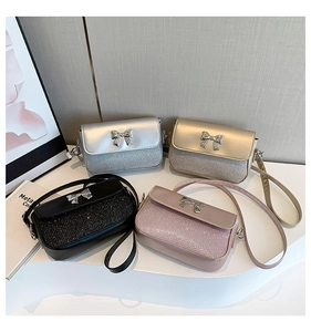 Close-up of stylish bow mini bags in silver, gold, black and pink with glitter textures