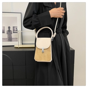 Detail of vintage cream and tan crossbody bag with metal clasp and structured top handle