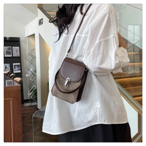 Retro small crossbody bag with silver ring buckle shown on a model in a modern room