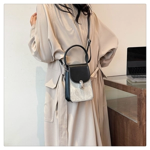 Mini crossbody bag in black and silver leather worn by a model in a beige coat