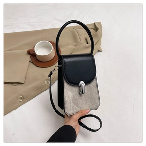Detail of contrast stitching and grey suede texture on a vintage crossbody phone bag