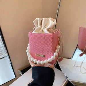 Sac seau tissé rose avec poignée en perles, bandoulière et cordon de serrage