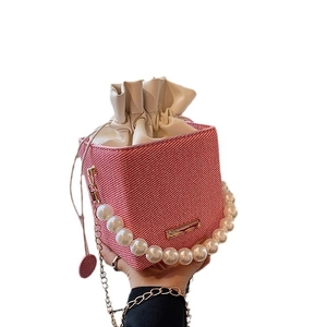 Sac seau rose avec poignée en perles, chaîne dorée et pochette intérieure à cordon