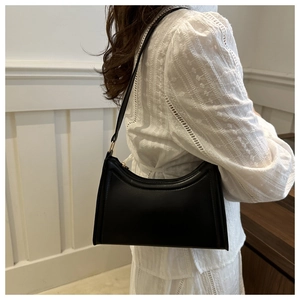 Detail of the vintage black leather crescent bag showing the stitching and gold zipper