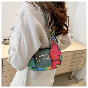 Detail of colorful geometric pattern hobo bag with denim texture and wavy metal buckle