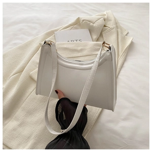 Detail of white baguette bag showing smooth PU leather and gold round hardware