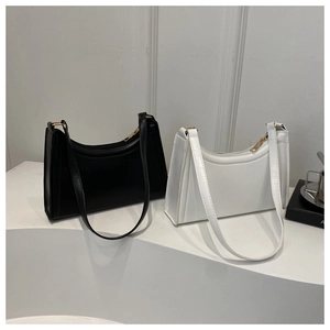 Detail view of black and white matte leather baguette bags with golden zippers