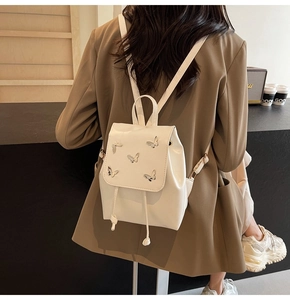 Cream white PU leather backpack with silver butterfly accents shown on a model's back
