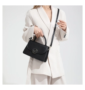 Gros plan d'un sac à main noir minimaliste avec fermoir magnétique doré chic