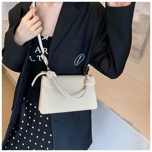 Detail of off-white crossbody bag with rope knot handle and textured PU leather