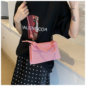 Detail of pink crossbody bag with thick braided top handle and diagonal woven texture