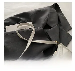 Détail du sac baguette blanc matelassé avec texture cuir et garnitures dorées élégantes