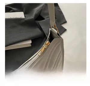 Détail du sac demi-lune en cuir matelassé blanc avec fermeture éclair dorée lisse