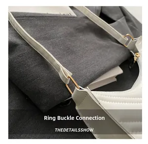 Détail du sac matelassé blanc montrant la boucle dorée et la jonction de la bandoulière