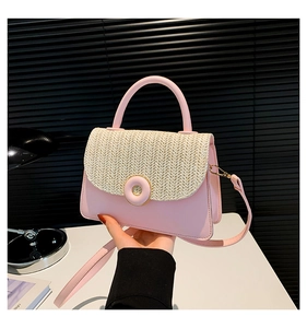 Detail van de roze lederen en geweven stro crossbodytas met magnetische gesp