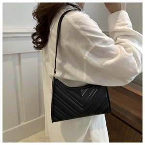 Détail du sac bandoulière noir en similicuir avec matelassage en V et boucles dorées