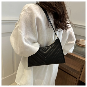 Vue détaillée du sac à bandoulière matelassé noir porté sur l'épaule du modèle