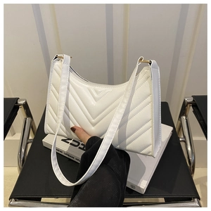 Détail du sac croissant blanc avec surpiqûres en V et anneaux métalliques dorés