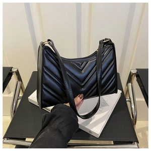 Vue détaillée du sac baguette noir avec surpiqûres en V et boucle en métal doré