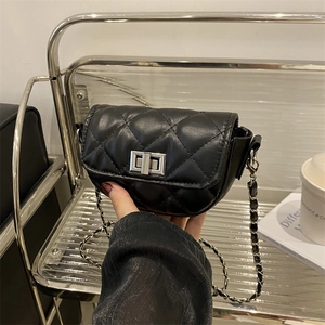 Minimalist black quilted chain crossbody bag with silver twist lock shown in hand