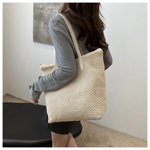 Borsa tote in paglia intrecciata bianco crema portata a spalla per stile quotidiano